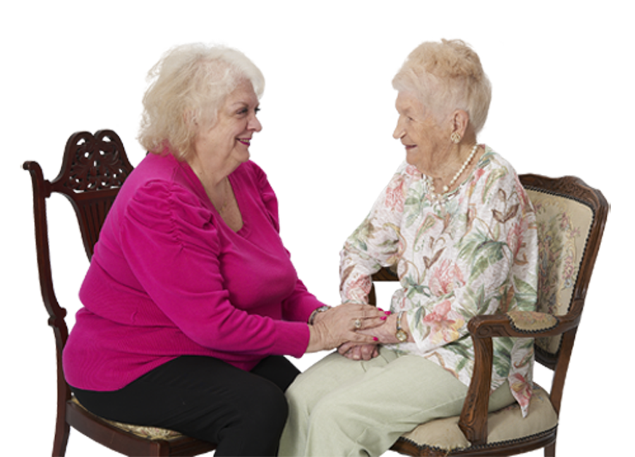 two women sitting in chairs and holding hands